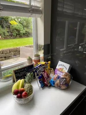 a counter with a bowl of food and a bowl of fruit at Home in Wirral - Peaceful Contemporary Gem. in Wirral