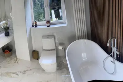 a white bathroom with a tub and a toilet at Home in Wirral - Peaceful Contemporary Gem. in Wirral