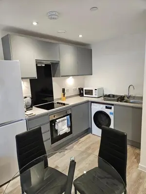 a kitchen with a table and two chairs in it at Liverpool modern family living in Liverpool