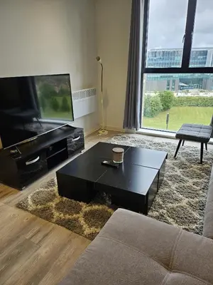 a living room with a black coffee table and a flat screen tv at Liverpool modern family living in Liverpool