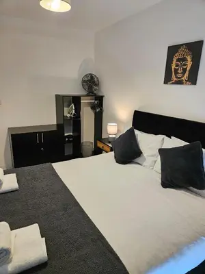 a bedroom with a large bed with black and white pillows at Liverpool modern family living in Liverpool