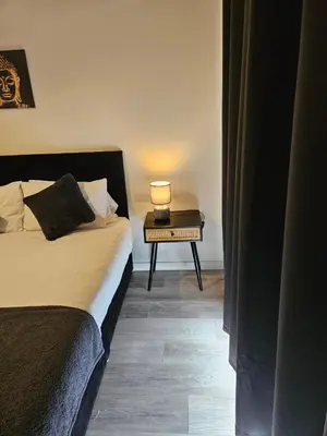 a bedroom with a bed and a table with a lamp at Liverpool modern family living in Liverpool