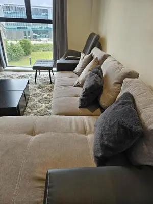 a couch with pillows in a living room with a window at Liverpool modern family living in Liverpool