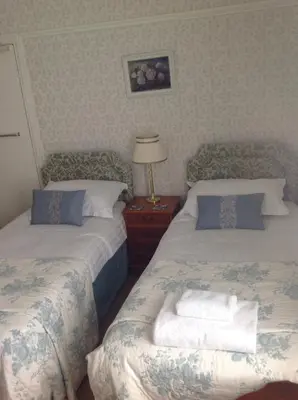 a bedroom with two beds and a lamp on a night stand at Yacht Bay View in Morecambe