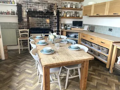 a kitchen with a wooden table with white chairs at Winter Escape with heated pool in Roby