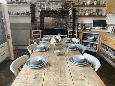 a wooden table with chairs and plates and wine glasses at Winter Escape with heated pool in Roby