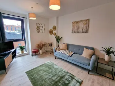 a living room with a blue couch and a television at Liverpool Baltic Flat in Liverpool