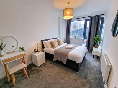 a bedroom with a bed with a mirror and a window at Liverpool Baltic Flat in Liverpool