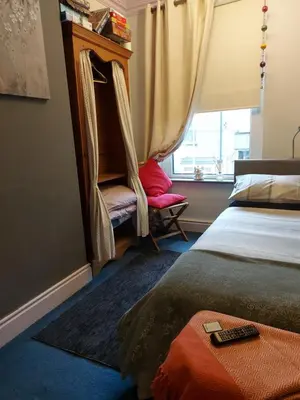 a bedroom with a bed and a chair and a window at Morecambe Seaside Room in Heysham