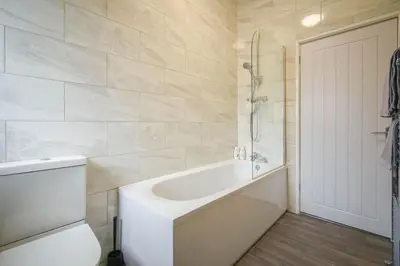 a white bathroom with a tub and a toilet at Home in the Heart of Accrington in Church