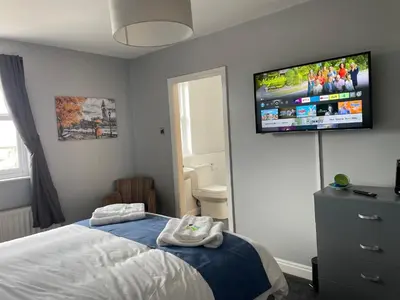 a bedroom with a bed and a flat screen tv on the wall at Feildens Arms Hotel in Blackburn