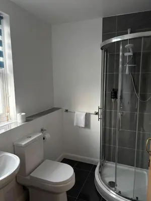 a bathroom with a shower and a toilet and a sink at Feildens Arms Hotel in Blackburn