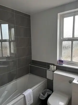 a bathroom with a white tub and a toilet at Feildens Arms Hotel in Blackburn