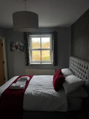 a bedroom with a large bed with a window at Feildens Arms Hotel in Blackburn