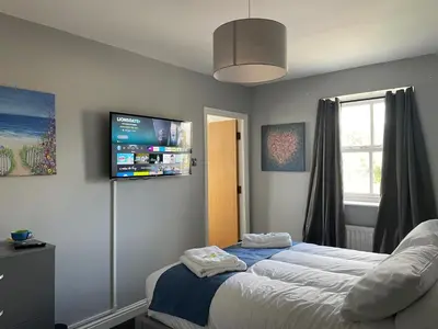 a bedroom with a bed and a flat screen tv at Feildens Arms Hotel in Blackburn