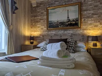 a bed with towels and a teddy bear on it at The New Guilderoy Hotel in Blackpool