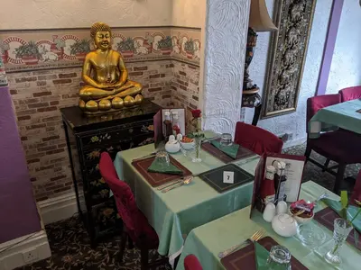 a dining room with two tables and a gold statue at The New Guilderoy Hotel in Blackpool