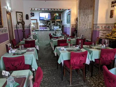 a restaurant with white tables and red chairs at The New Guilderoy Hotel in Blackpool