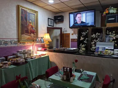 a restaurant with green tables and a tv on the wall at The New Guilderoy Hotel in Blackpool