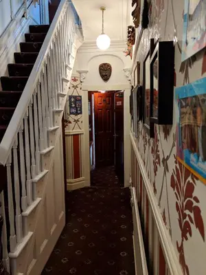 a hallway with stairs in a house with a ceiling at The New Guilderoy Hotel in Blackpool