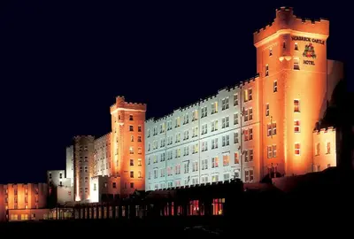 a large building with two towers at night at Norbreck Castle Hotel in Blackpool