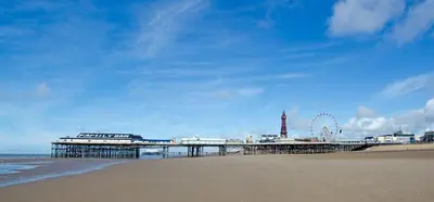 a pier on the beach with a ferris wheel in the background at Norbreck Castle Hotel in Blackpool