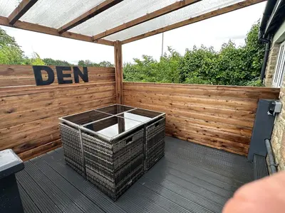 a deck with a wooden fence and a bench at 2 The Cottage in Upholland