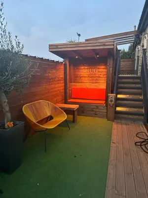 a wooden deck with a bench and a dog house at 2 The Cottage in Upholland