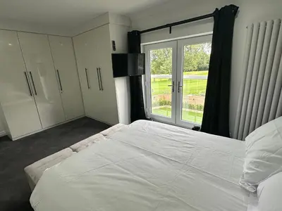 a bedroom with a large white bed and a window at 2 The Cottage in Upholland