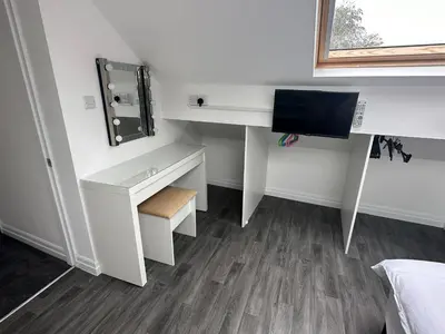 a white desk with a mirror and a computer at 2 The Cottage in Upholland
