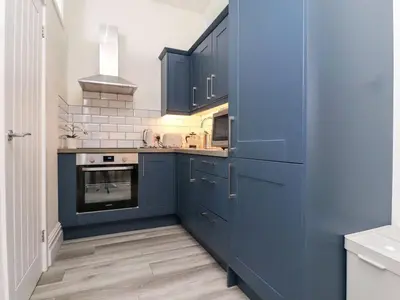 a kitchen with blue cabinets and a stove at The Hideaway - Perfect couples retreat with Free parking on driveway in Lytham St Annes