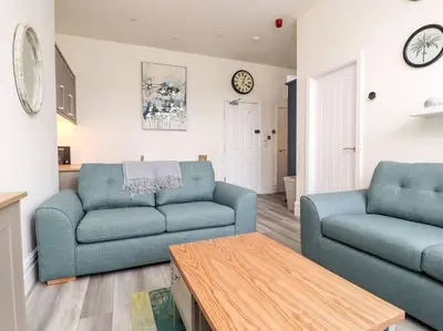 a living room with two blue couches and a table at The Hideaway - Perfect couples retreat with Free parking on driveway in Lytham St Annes