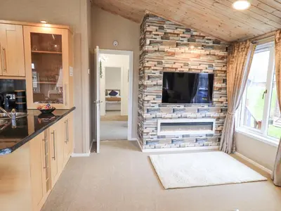 a living room with a tv on a brick wall at Our Happy Place in Carnforth