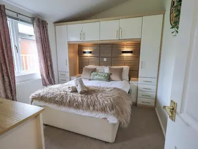 a bedroom with a bed with a furry blanket on it at Our Happy Place in Carnforth