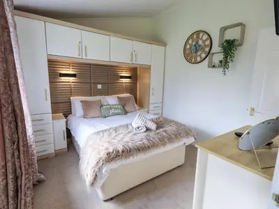 a bedroom with a bed with a fur blanket on it at Our Happy Place in Carnforth