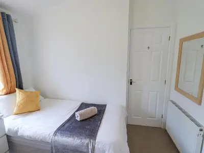 a small bedroom with a bed with a pillow on it at Our Happy Place in Carnforth