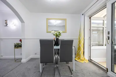 a dining room with a table with chairs and a vase of flowers at E&E's House in Cherry Tree