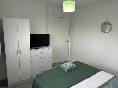 a bedroom with a bed and a flat screen tv at E&E's House in Cherry Tree