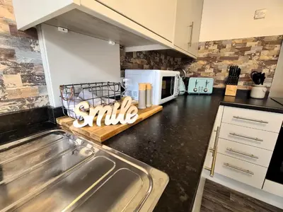 a kitchen with a sink and a white microwave at Tower Views 2 Bedroom House with Private Parking in Blackpool