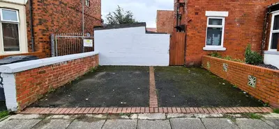 a parking lot in front of a brick building at Tower Views 2 Bedroom House with Private Parking in Blackpool