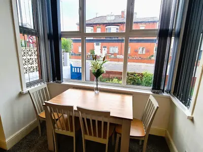 a vase of flowers sitting on a table in front of a window at Tower Views 2 Bedroom House with Private Parking in Blackpool