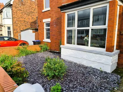 a garden in front of a house with a window at Tower Views 2 Bedroom House with Private Parking in Blackpool