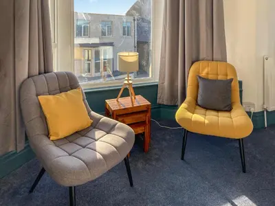 two chairs and a lamp in a room with a window at Blue Sands in Morecambe