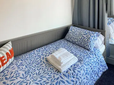 a bed with a blue and white sheets and pillows at Blue Sands in Morecambe