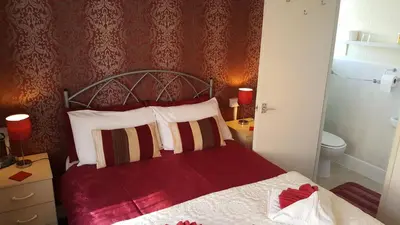 a bedroom with a bed with a red wall at The Middleton in Blackpool