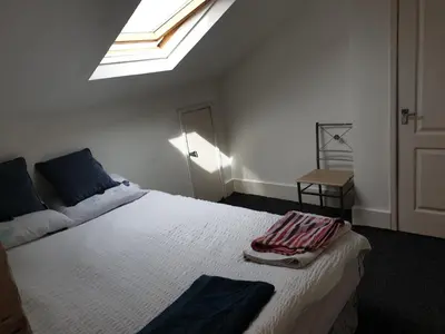 a bedroom with a large white bed with a skylight at Townsend Studio/Rooms in Liverpool
