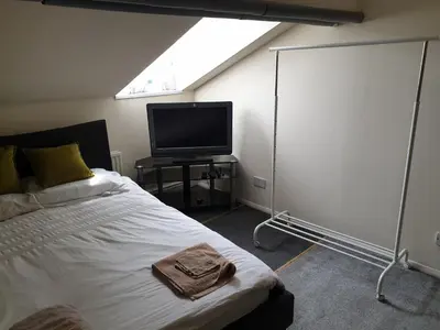 a bedroom with a bed and a flat screen tv at Townsend Studio/Rooms in Liverpool
