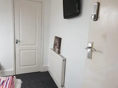 a room with a door with a television on the wall at Townsend Studio/Rooms in Liverpool