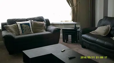 a living room with two couches and a table at OLIVERS Strickley over 35 years only in Blackpool