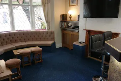 a waiting room with a couch and stools at OLIVERS Strickley over 35 years only in Blackpool
